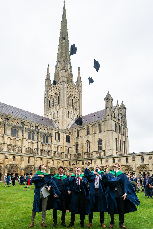 Graduates celebrating in the grounds of Norwich Cathedral