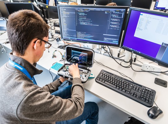 Student using computing hardware and software side by side