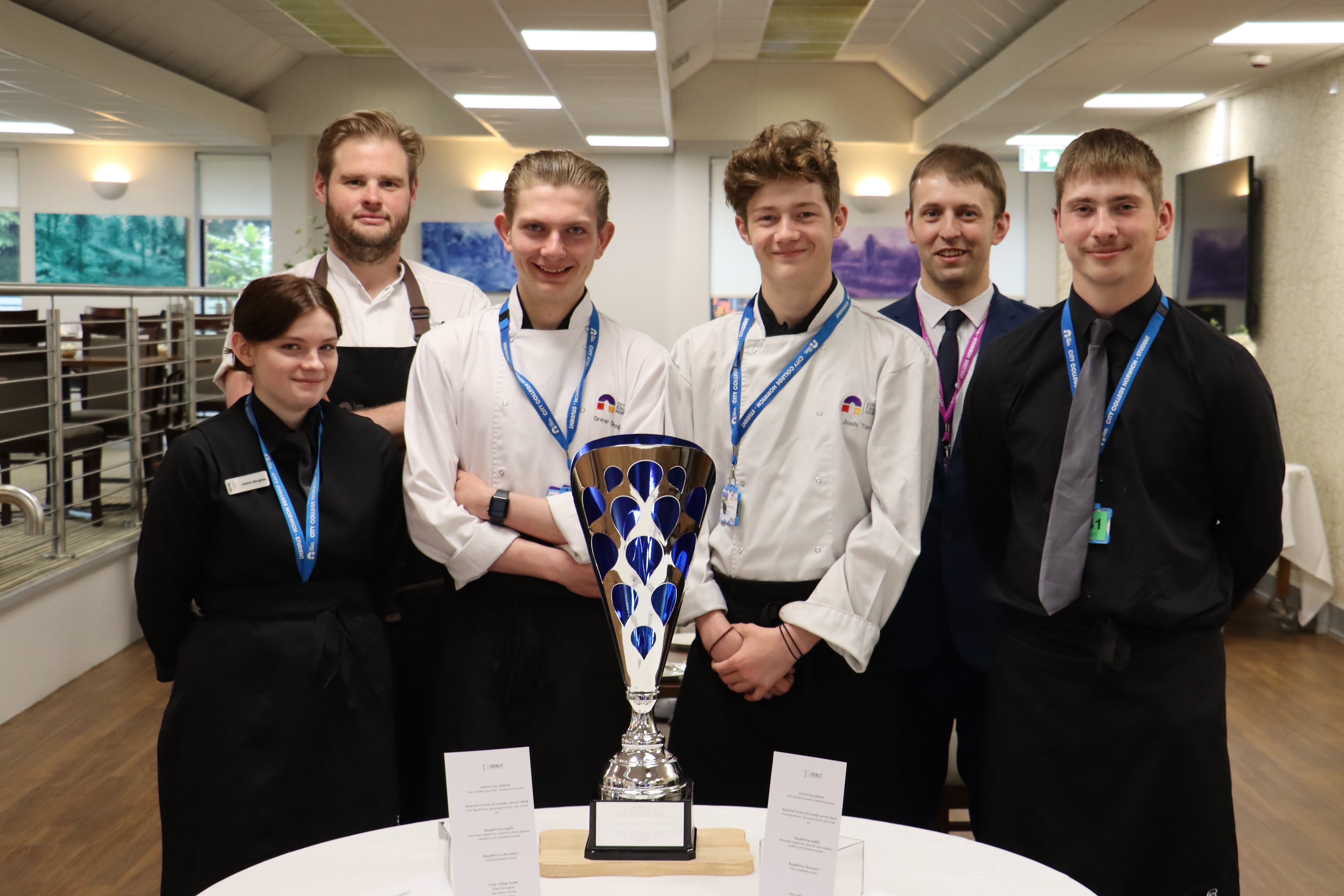 Students in chef whites posing with their trophy