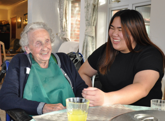 Student chatting to an elderly resident in a care home