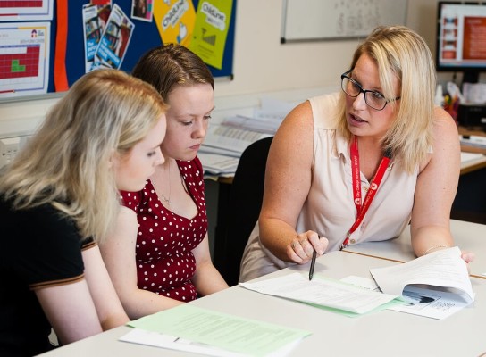 City College teacher with two students at desk